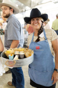 Volunteer serving snacks at cowboy ball